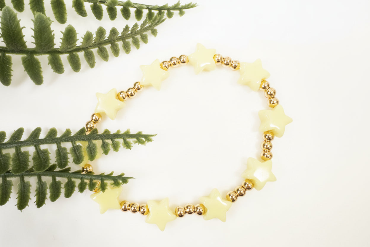 Star-shaped bracelet with gold beads on a light background